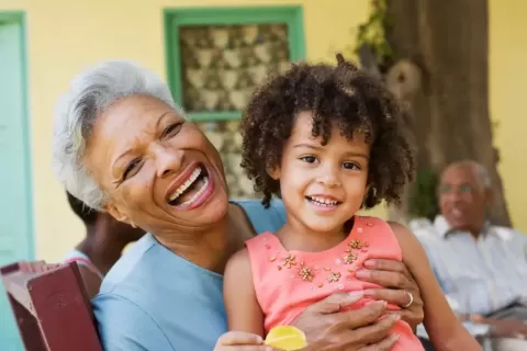 Imagem de avó e neta juntas sorrindo.